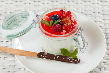 Panna cotta with fruit and chocolate sticks on a light