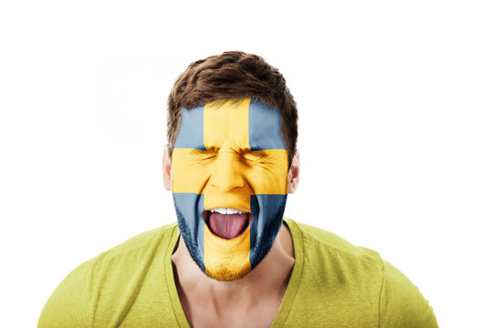 Screaming man with Sweden flag on face.