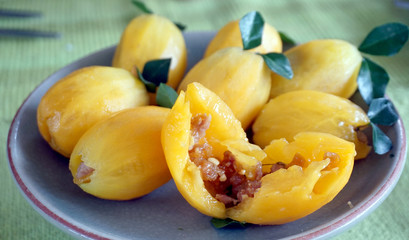 Fusion Thai food, orange plum fruit stuffed with meat