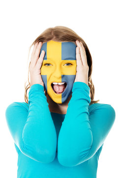 Woman with Sweden flag on face.