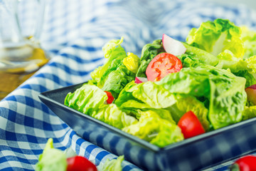 Fresh lettuce salad with cherry tomatoes  radish and carafe with