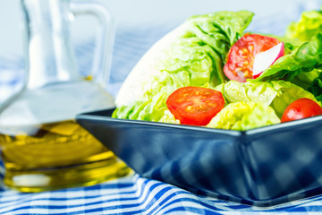 Fresh lettuce salad with cherry tomatoes  radish and carafe with