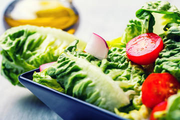 Fresh lettuce salad with cherry tomatoes  radish and carafe with
