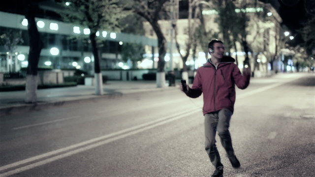 Funny guy walk down the night street city, free dancing to music