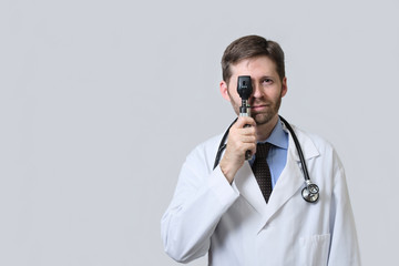 Doctor looking through ophtalmoscope with both eyes open