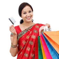Young smiling traditional woman with shopping bags and credit ca