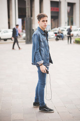 young handsome alternative dark model man in town listening to m