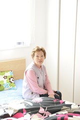 ベッドの上に座っている高齢者の女性