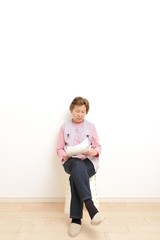 何もないシンプルな部屋と高齢者のアジア人女性