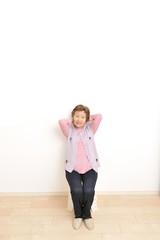 何もないシンプルな部屋と高齢者のアジア人女性