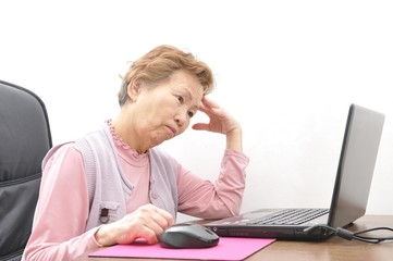 難しいパソコン作業をしている高齢者の日本人女性