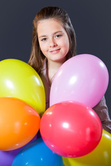 Fototapeta na wymiar Girl with long hair posing in the studio with ballons