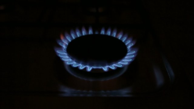 A natural gas oven flames in dark, ignition and fading