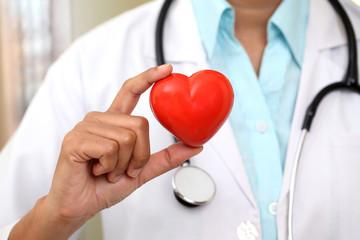 Female doctor holding a beautiful red heart shape - 81799054