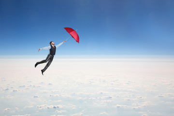 Man flying in the sky with umbrella