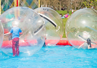 Kinder spielen im transparenten Wasserball