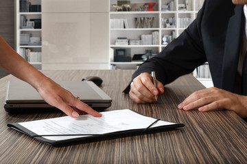 female hand pointing to businessman at signature place on a cont