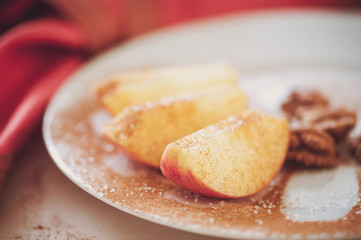 apple is sliced into wedges with cinnamon.