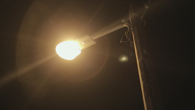 Ignited and fading  street-lamp at night on street