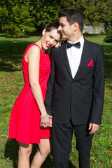 Loving couple in bright clothes dancing on the park
