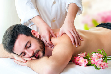 Therapist doing back massage on young man.