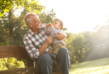 Playful grandfather spending time with his grandson in park