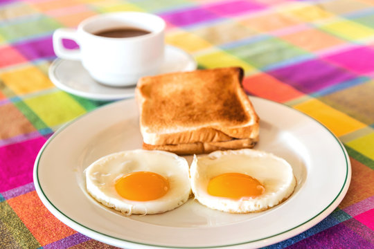 Fried Eggs And Toasts For Breakfast With Coffee Background