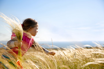 Cute little girl picking grasses