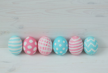 Pink and blue eggs on a wooden background
