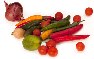 Heap of bright chili peppers, cherry tomatoes, lime, onions
