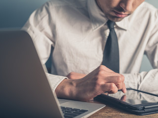 Businessman using laptop and tablet