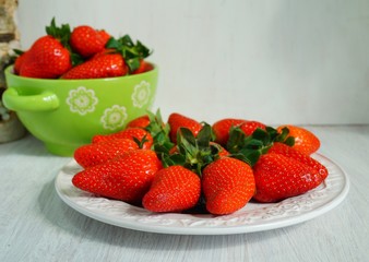 fresh strawberries on a white plate and colorful dish