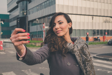 Beautiful girl taking a selfie in an urban context