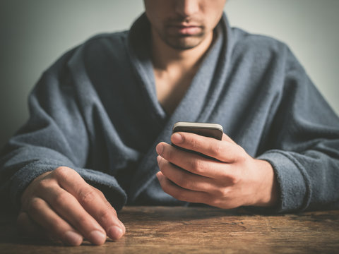 Man in bathrobe using smart phone