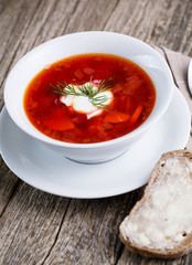 Tasty soup with bread on a wooden background.