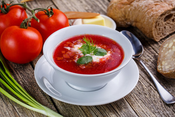 Tasty soup with bread on a wooden background.