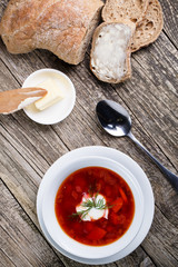 Tasty soup with bread on a wooden background.