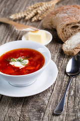 Tasty soup with bread on a wooden background.
