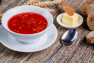Tasty soup with bread on a wooden background.