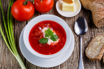 Tasty soup with bread on a wooden background.