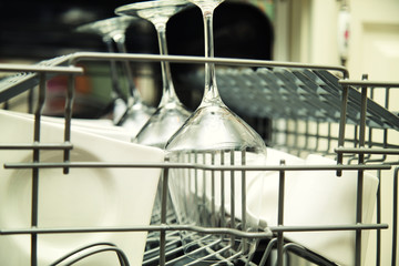 Kitchen Woman with a clean wine glass on background dishwasher