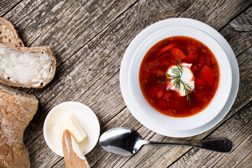 Tasty soup with bread on a wooden background.