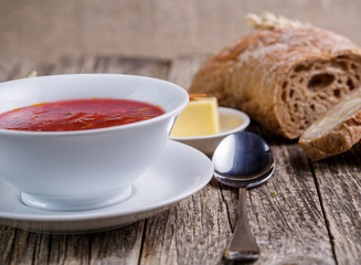 Tasty soup with bread on a wooden background.