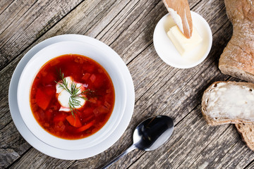 Tasty soup with bread on a wooden background.