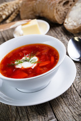 Tasty soup with bread on a wooden background.