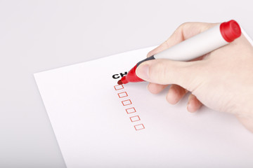 Checklist on white with marker and woman hand
