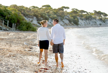 young couple in love walking on beach romantic summer holidays
