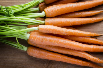 Fresh carrots on the wooden background.