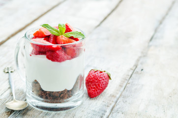 layered dessert with strawberries, chocolate biscuit cake and cr