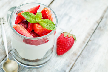 layered dessert with strawberries, chocolate biscuit cake and cr
